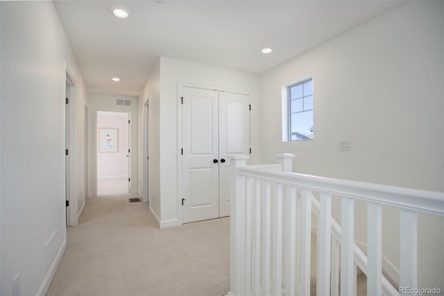 hallway with light colored carpet