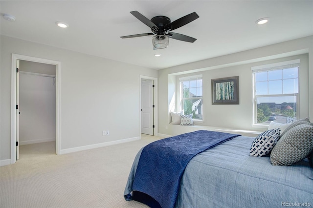 carpeted bedroom with ceiling fan and a spacious closet