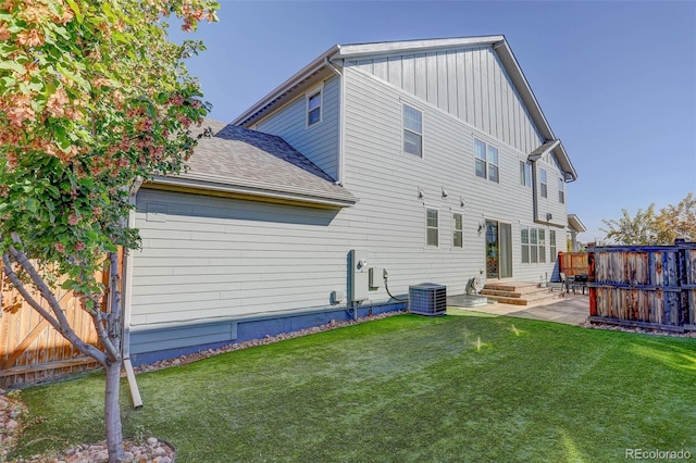 back of house with central AC, a patio area, and a yard