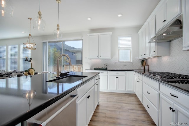 kitchen featuring decorative light fixtures, sink, light hardwood / wood-style flooring, and a wealth of natural light