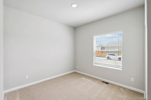 spare room featuring baseboards, carpet flooring, and visible vents