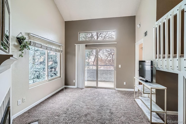 living room with a high ceiling and carpet