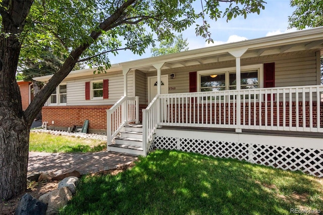 6749 S Foresthill St, Littleton, CO 80120 - ranch-style home with a porch, brick siding, and a front yard
