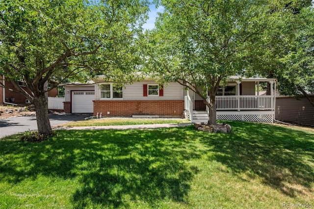 6749 S Foresthill St, Littleton, CO 80120 - obstructed view of property featuring covered porch, asphalt driveway, brick siding, a garage, and a front yard