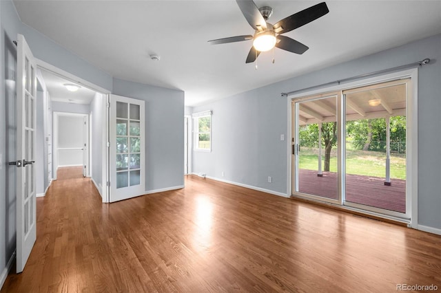 6749 S Foresthill St, Littleton, CO 80120 - spare room with wood finished floors, ceiling fan, a smoke detector, and french doors