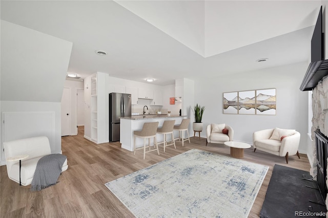 225 E 8th Ave Unit A2, Longmont, CO 80504 - living area featuring a fireplace with flush hearth, light wood finished floors, and baseboards