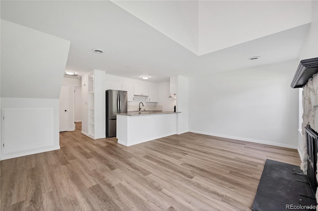 225 E 8th Ave Unit A2, Longmont, CO 80504 - unfurnished living room with light wood finished floors, a fireplace with flush hearth, baseboards, and a sink