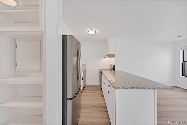 225 E 8th Ave Unit A2, Longmont, CO 80504 - kitchen featuring appliances with stainless steel finishes, white cabinets, light wood-style flooring, light stone counters, and a peninsula