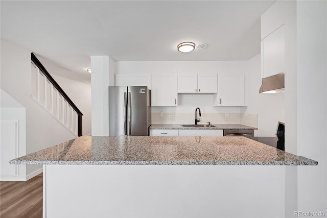 225 E 8th Ave Unit A2, Longmont, CO 80504 - kitchen featuring freestanding refrigerator, a sink, white cabinets, light stone countertops, and wood finished floors
