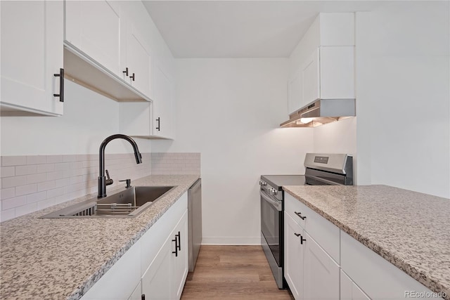 225 E 8th Ave Unit A2, Longmont, CO 80504 - kitchen with under cabinet range hood, appliances with stainless steel finishes, a sink, backsplash, and white cabinetry