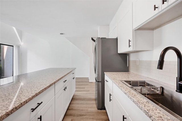 225 E 8th Ave Unit A2, Longmont, CO 80504 - kitchen with a sink, light wood-type flooring, white cabinets, and decorative backsplash