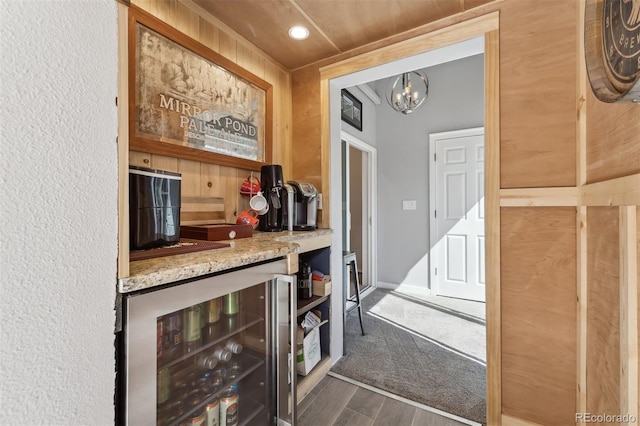 8700 S Ammons St, Littleton, CO 80128 - indoor dry bar with wine cooler, wood finished floors, a chandelier, and recessed lighting