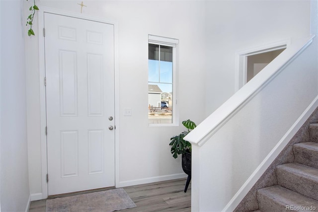 entryway featuring stairway, baseboards, and wood finished floors