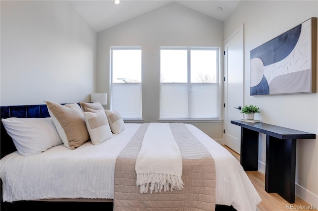 bedroom featuring light hardwood / wood-style flooring and lofted ceiling