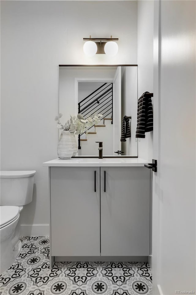 bathroom with tile patterned flooring, vanity, and toilet