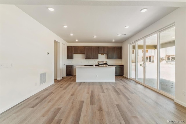 455 S Salida St, Aurora, CO 80017 - kitchen featuring light wood finished floors, stainless steel stove, dark brown cabinetry, a sink, and light countertops