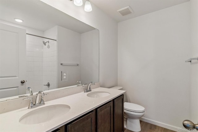 455 S Salida St, Aurora, CO 80017 - bathroom featuring toilet, double vanity, wood finished floors, baseboards, and a shower