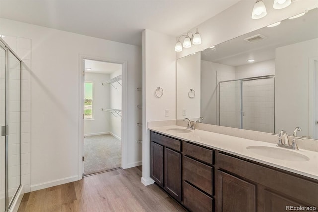 455 S Salida St, Aurora, CO 80017 - full bath with wood finished floors, a shower stall, double vanity, baseboards, and a walk in closet