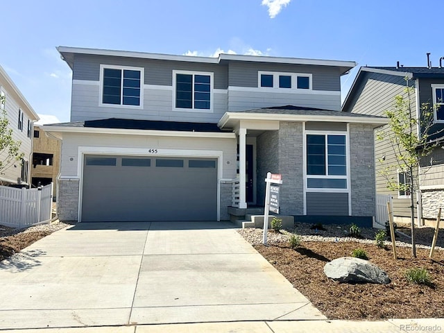 455 S Salida St, Aurora, CO 80017 - view of front facade featuring stone siding, driveway, and an attached garage