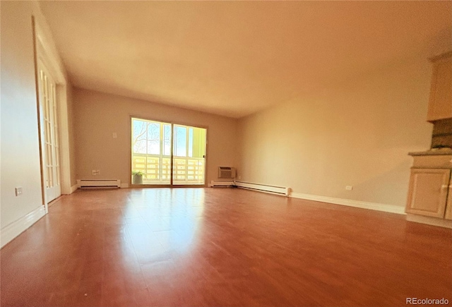 unfurnished living room with a baseboard heating unit, baseboards, and wood finished floors