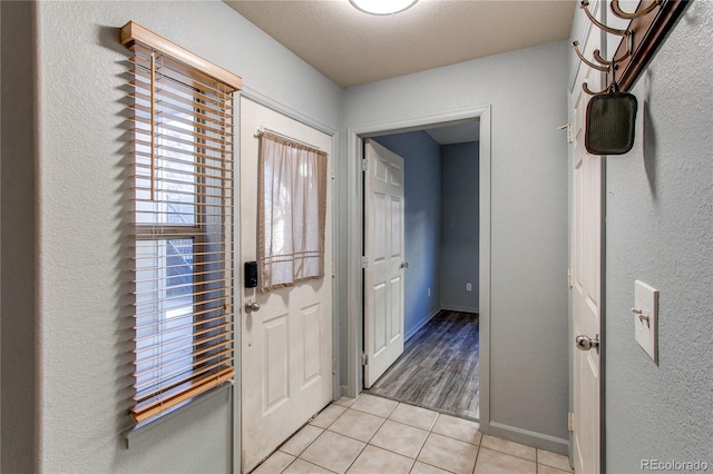 entrance foyer featuring light tile patterned floors and a textured ceiling