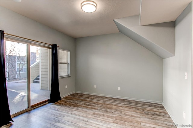 empty room with light hardwood / wood-style floors and a textured ceiling