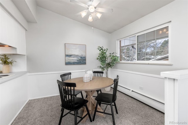 carpeted dining room with ceiling fan, a baseboard heating unit, and lofted ceiling