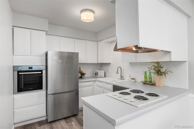 kitchen featuring sink, backsplash, white cabinetry, and stainless steel appliances