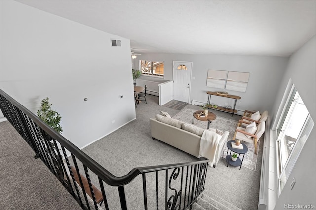 living room with baseboard heating, carpet flooring, and vaulted ceiling