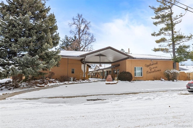 view of snow covered rear of property