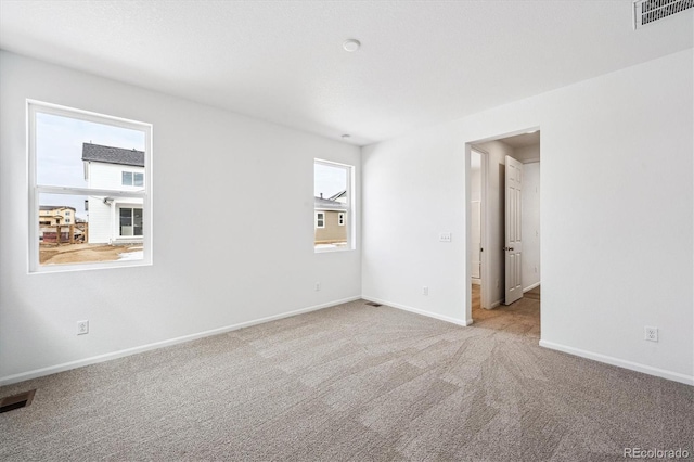 unfurnished room featuring light carpet