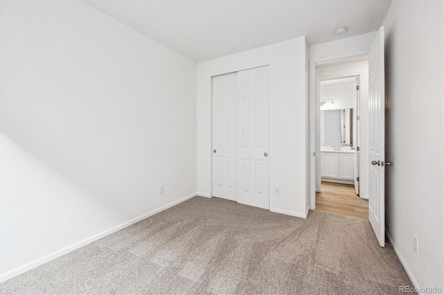 unfurnished bedroom featuring light colored carpet and a closet