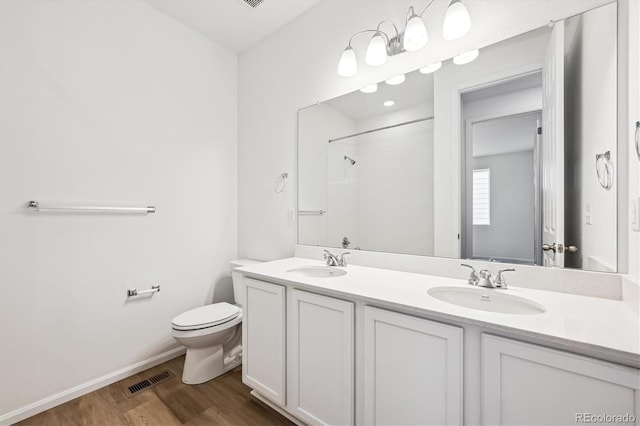 bathroom featuring walk in shower, toilet, vanity, and hardwood / wood-style flooring