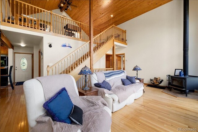167 Wapiti Ct, Canon City, CO 81212 - living room with high vaulted ceiling, a wood stove, wood ceiling, wood-type flooring, and stairs