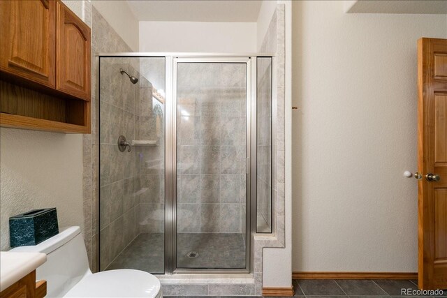 167 Wapiti Ct, Canon City, CO 81212 - bathroom featuring a stall shower, toilet, tile patterned flooring, and baseboards