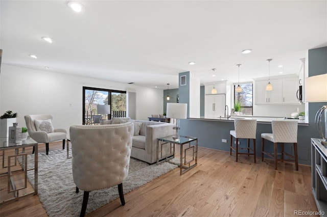 living room with light wood finished floors and recessed lighting