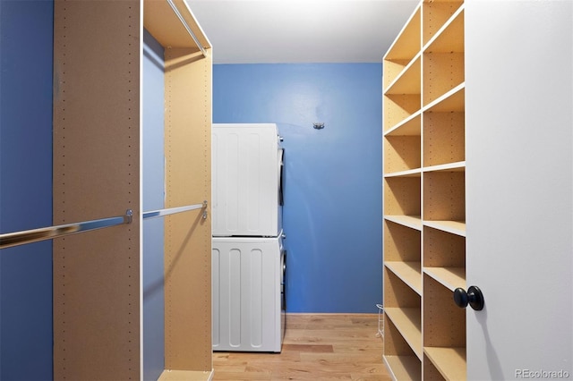 spacious closet with stacked washer and dryer and wood finished floors