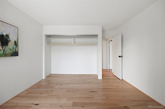 unfurnished bedroom featuring light wood-type flooring and a closet