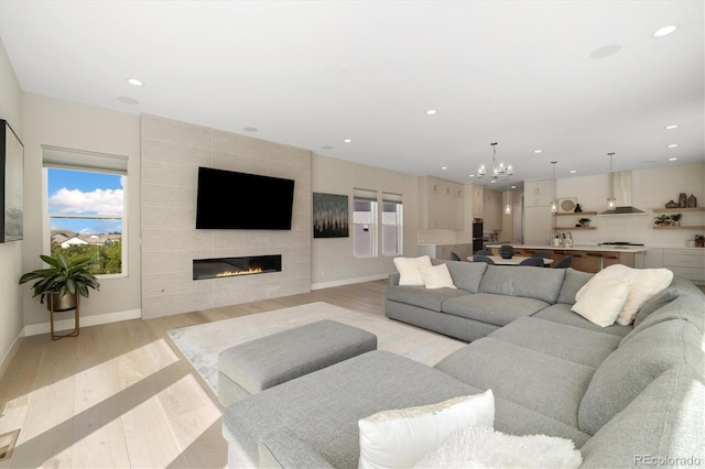 2221 Rim Ridge Dr, Castle Pines, CO 80108 - living area with a chandelier, recessed lighting, a fireplace, and light wood-type flooring