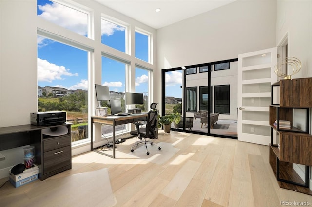 2221 Rim Ridge Dr, Castle Pines, CO 80108 - home office featuring wood finished floors, a towering ceiling, and recessed lighting