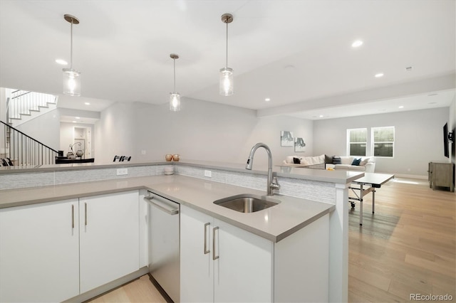 2221 Rim Ridge Dr, Castle Pines, CO 80108 - kitchen with dishwasher, open floor plan, white cabinets, pendant lighting, and light wood-type flooring