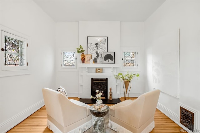 interior space featuring baseboards, visible vents, light wood-style floors, and a fireplace