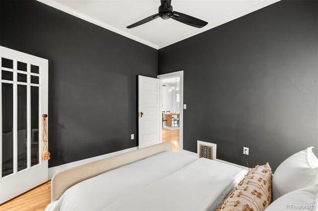 bedroom featuring visible vents, ornamental molding, ceiling fan, and wood finished floors