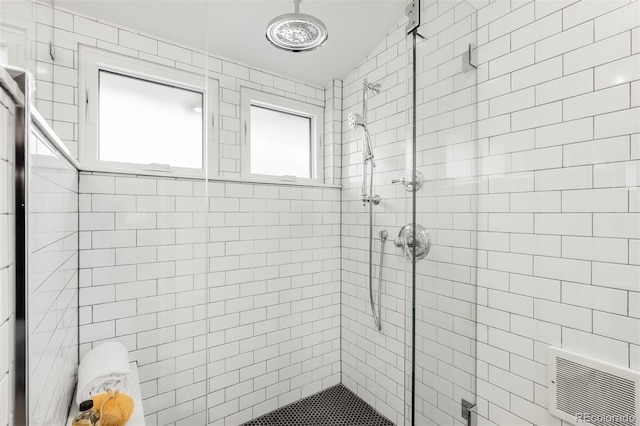 bathroom with a stall shower and visible vents