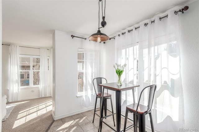 dining area with plenty of natural light, baseboards, and light tile patterned floors