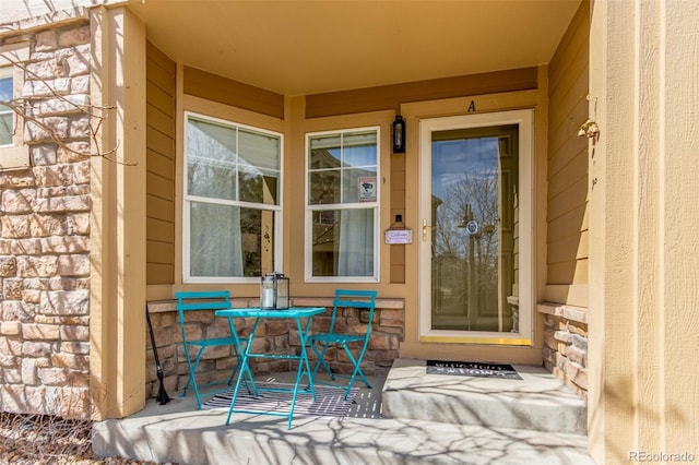 property entrance with a porch and stone siding