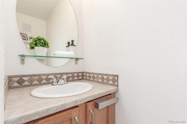 bathroom with tasteful backsplash, vanity, and visible vents
