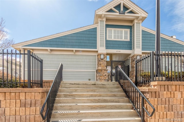 view of front of home with stairway and fence