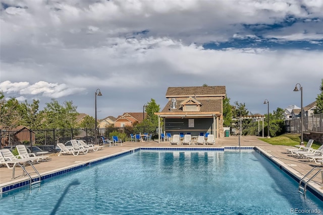pool with fence and a patio area