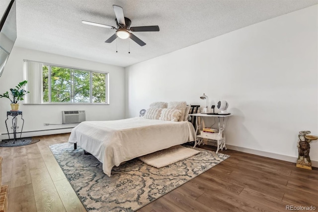 bedroom with dark hardwood / wood-style floors, a baseboard radiator, a wall unit AC, and ceiling fan